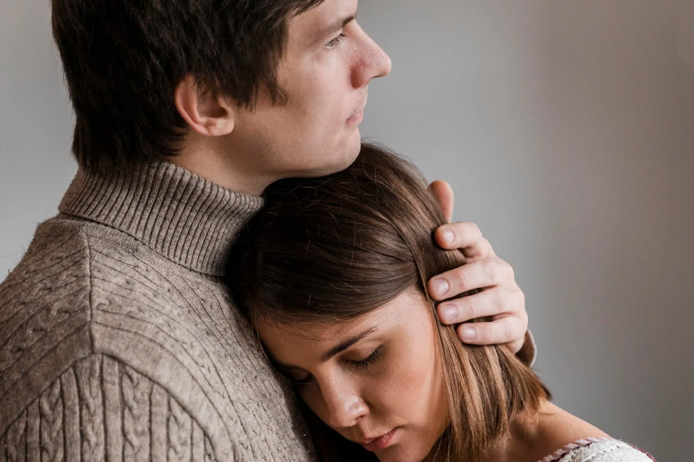Couple enlacé, la femme les yeux fermés contre l’épaule de son conjoint : douleurs pendant les rapports liées à un fibrome